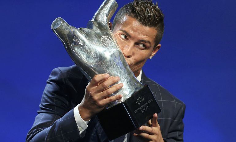 Cristiano Ronaldo besa el premio al mejor jugador de Europa que le ha concedido la UEFA en el acto en el que también se ha celebrado el sorteo de la fase de grupos de la Champions League.