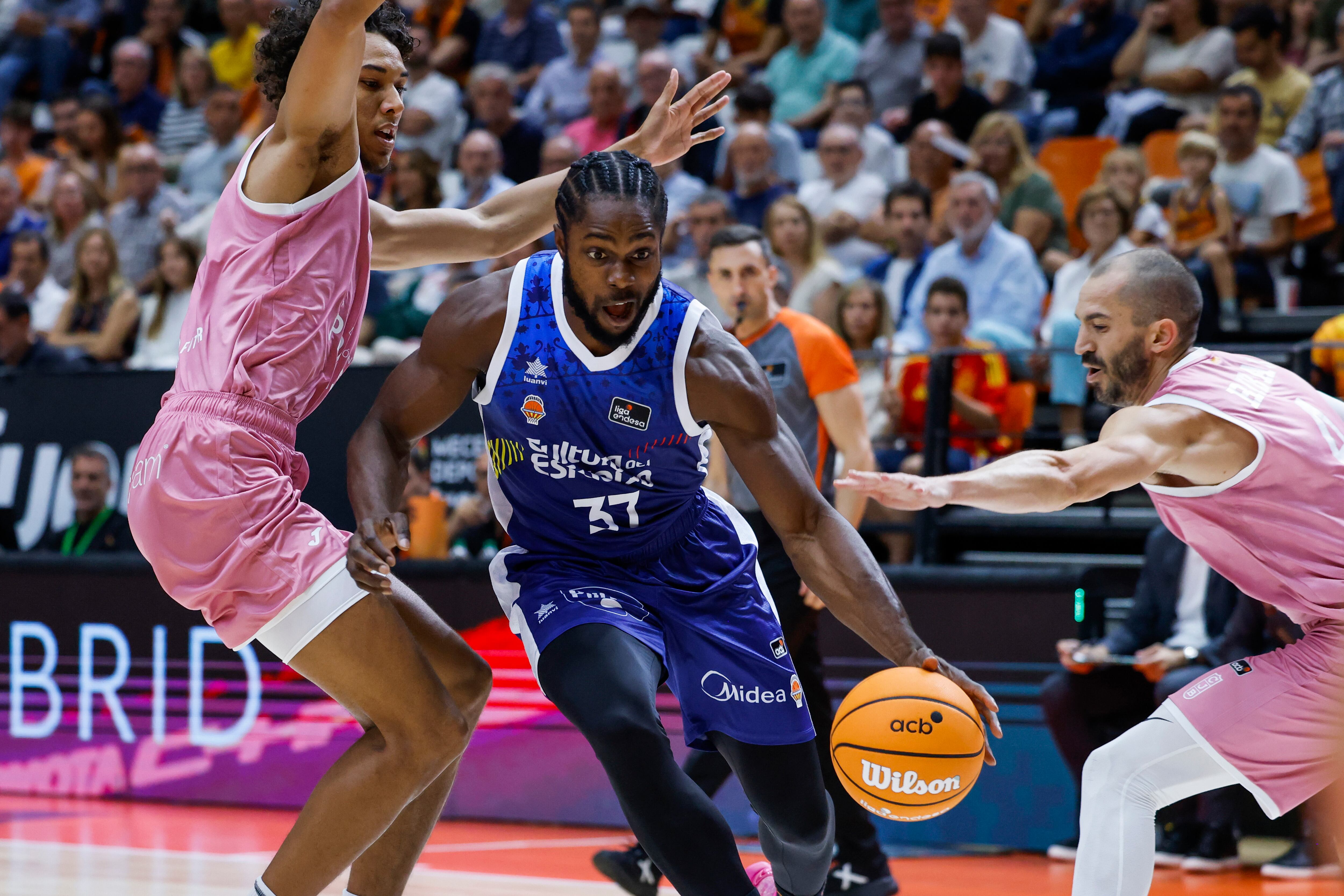 VALENCIA, 05/10/2024.- El alero del Valencia Basket Semi Ojeleye (c) avanza con el balón junto a Pau Rivas (d), del Joventut, durante el encuentro de Liga ACB que Valencia Basket y Joventut de Badalona disputan este sábado en La Fuente de San Luis. EFE/Ana Escobar
