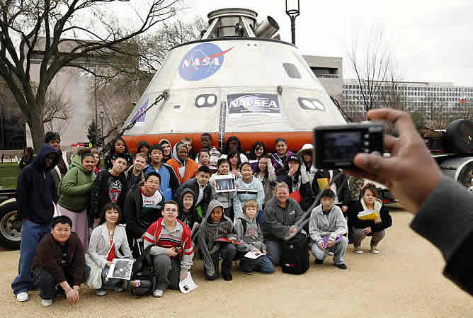 Un grupo de estudiantes se fotografía junto a la maqueta de la futura cápsula lunar de la NASA, presentada en Washington