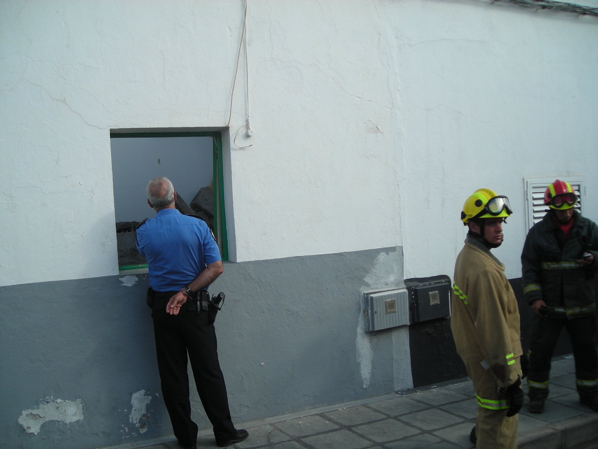 Bomberos y policías junto a la casa que se derrumbó en 2009.