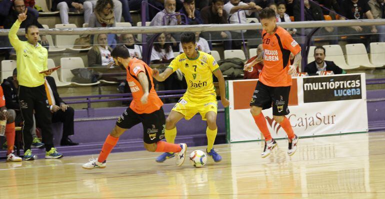 El jugador del Jaén Paraíso Interior, Felipinho, se disputa el balón con dos contrincantes del Burela.