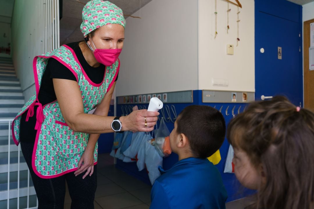 Una maestra controla la temperatura de los niños en una escuela de Valladolid, en junio de 2020.