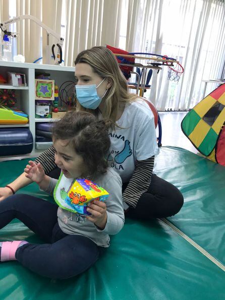 Imagen de Lola jugando con su fisioterapeuta