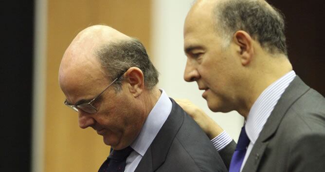 El ministro español de Economía, Luis de Guindos, conversa con el ministro francés de Finanzas, Pierre Moscovici, durante la reunión informal de ministros de Finanzas del Eurogrupo celebrada en Nicosia (Chipre).