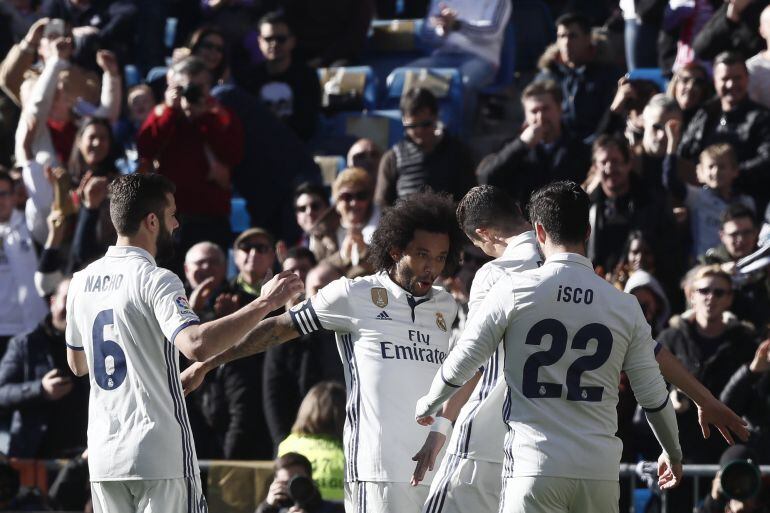 El delantero portugués del Real Madrid Cristiano Ronaldo (2d) celebra con sus compañeros su gol ante el Granada, tercero para el conjunto blanco, durante el partido de la décimo séptima jornada de Liga de Primera División disputado esta mañana en el estad