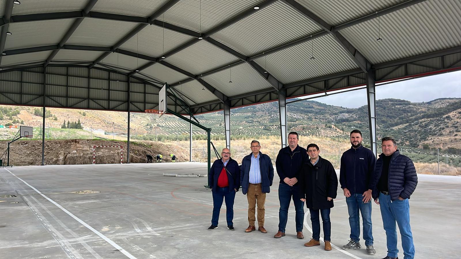 El alcalde de Pegalajar, Manuel Carrascosa; y el presidente de la Diputación de Jaén, Francisco Reyes (tercero y cuarto por la izqda), durante su visita a la pista polideportiva de Pegalajar.