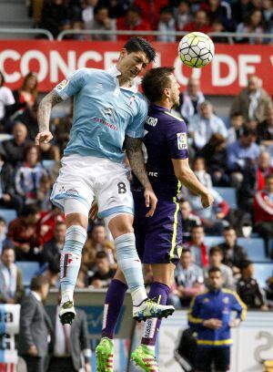 El centrocampista chileno del Celta de Vigo Pablo Hernández (i) salta por el balón junto a Camacho, del Málaga