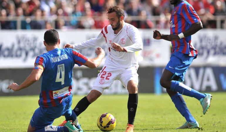 Sevilla's midfielder Aleix Vidal (C) vies with Levante's defender David Navarro (L) during the Spanish league football match Sevilla vs Levante at the Ramon Sanchez Pizjuan stadium in Seville on November 9, 2014.   The match ended in a draw 1-1. AFP PHOTO/ CRISTINA QUICLER