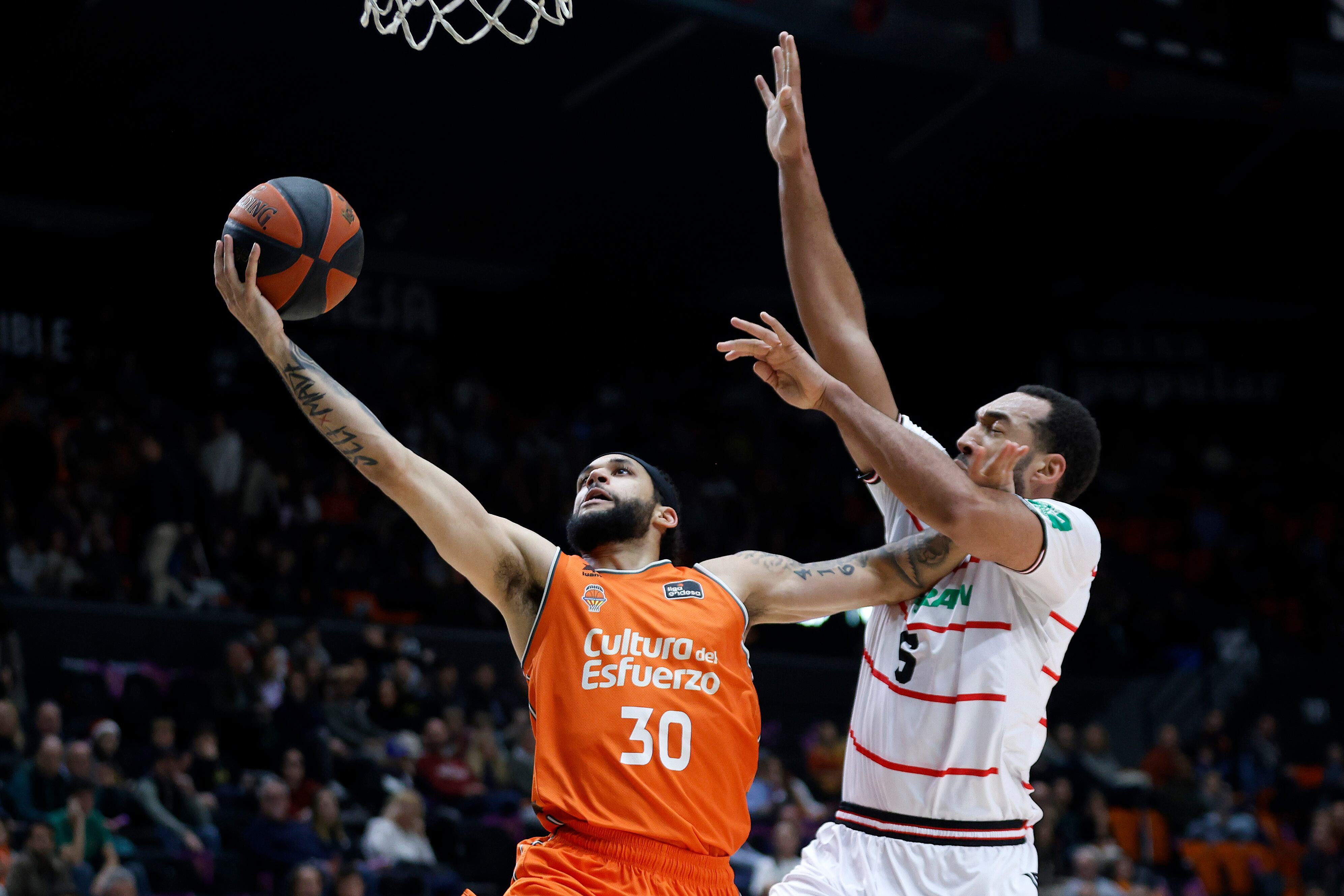 VALENCIA, 23/12/2023.- El jugador del Covirán Granada Kwan Cheatham (d) ante Kassius Robertson (i), del Valencia Basket, durante un encuentro correspondiente a la jornada 15 de la Liga Endesa disputado hoy sábado en el pabellón de la Fuente de San Luis de Valencia. EFE/ Miguel Ángel Polo