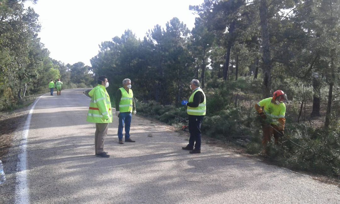 El alcalde de Aldeaquemada, Manuel Fernández (centro), visita las tareas de poda en Aldeaquemada.
