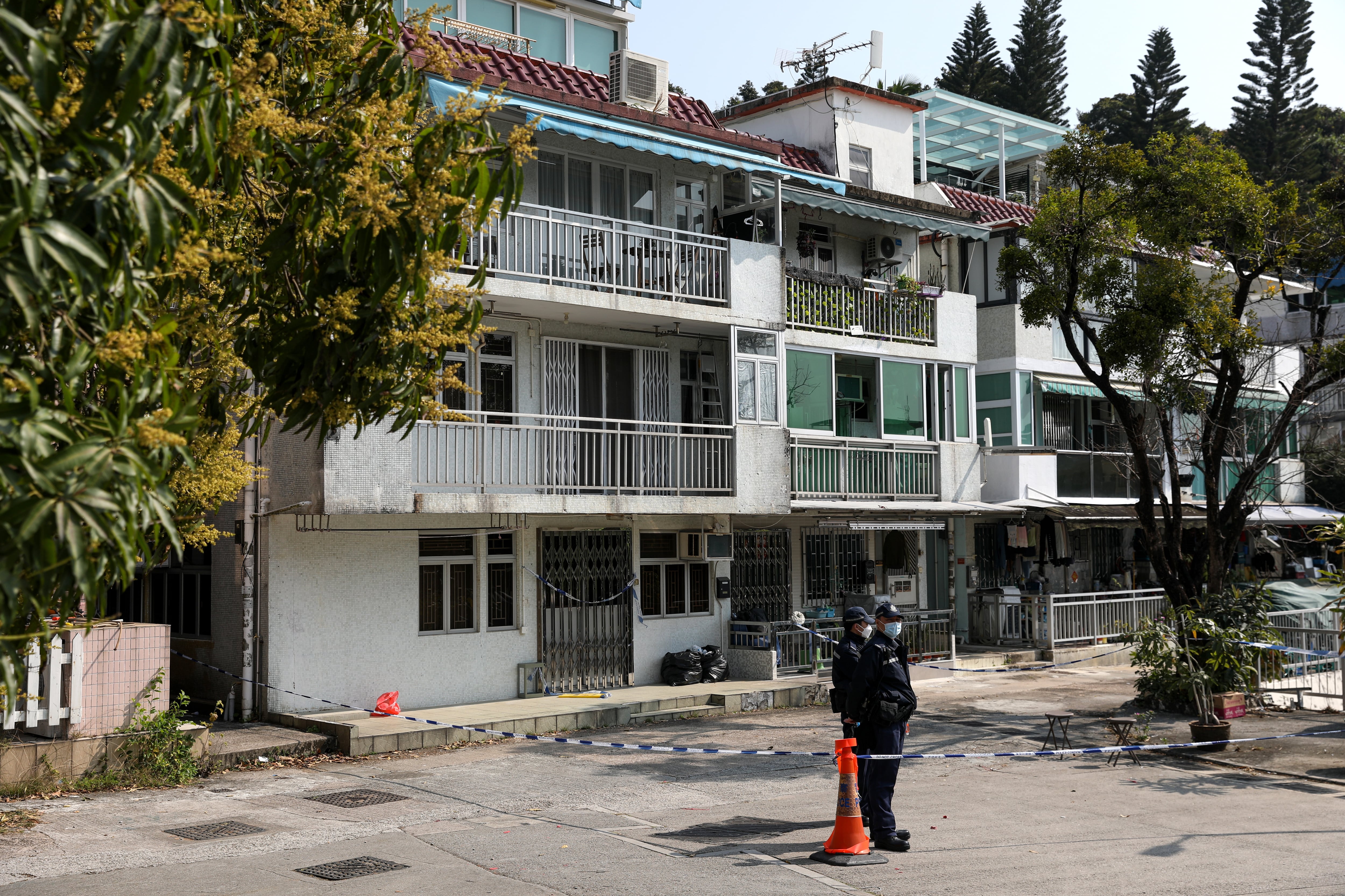 La policía hace guardia frente a una casa de pueblo donde se encontraron los restos de la modelo Abby Choi 