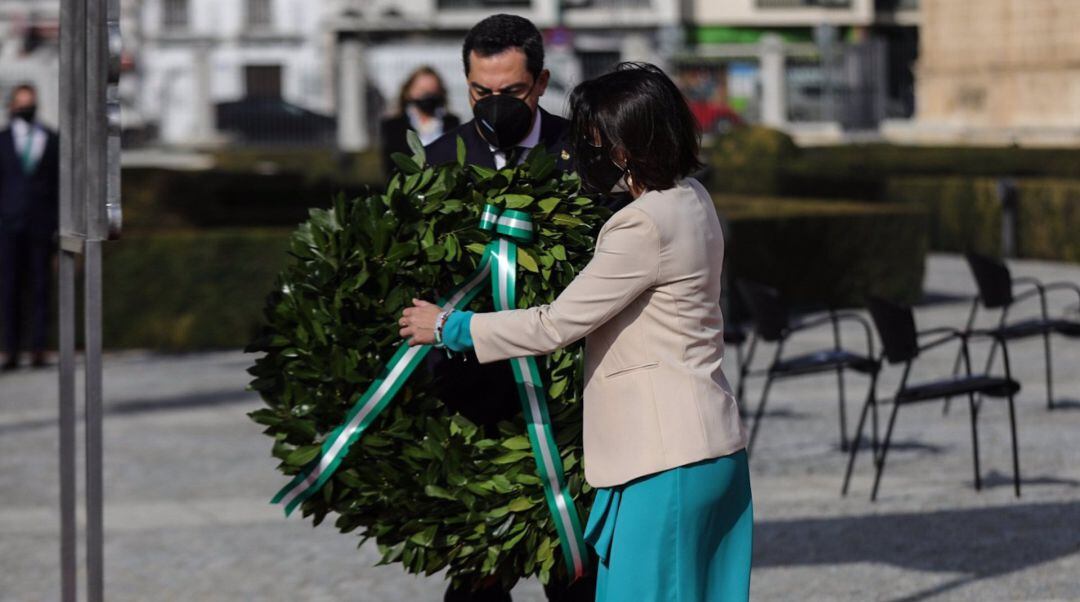 El presidente de la Junta de Andalucía, Juanma Moreno, y la presidenta del Parlamento, Marta Bosquet, realizan una ofrenda floral en el acto por el Día de Andalucía en recuerdo de los fallecidos por la pandemia.