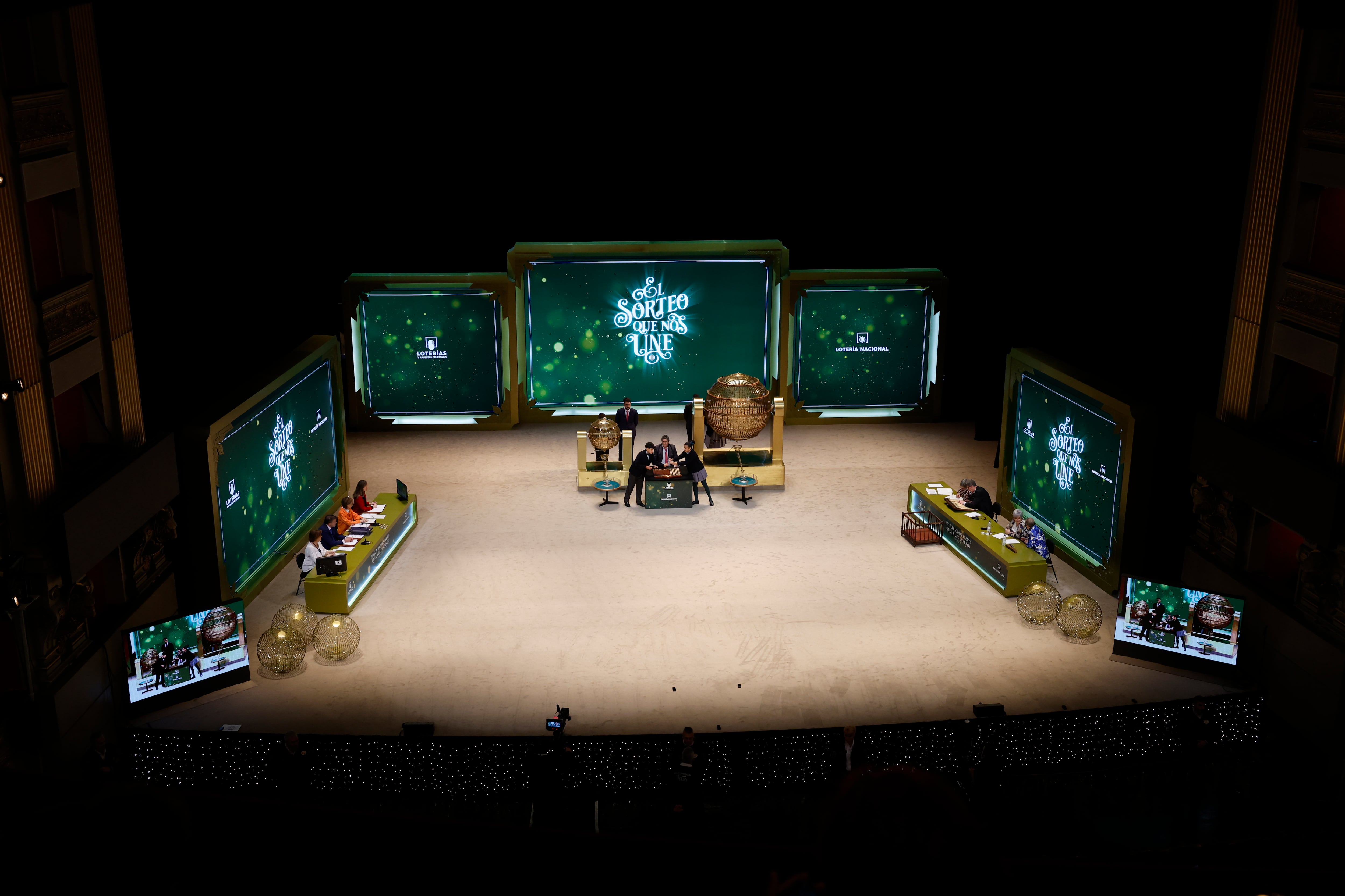 MADRID, 22/12/2023.- Dos niños de San Ildefonso cantan los números y sus correspondientes premios ante uno de los representantes de Loterías durante el sorteo extraordinario de Navidad de la Lotería Nacional este viernes en el Teatro Real de Madrid. EFE/ J.J. Guillén
