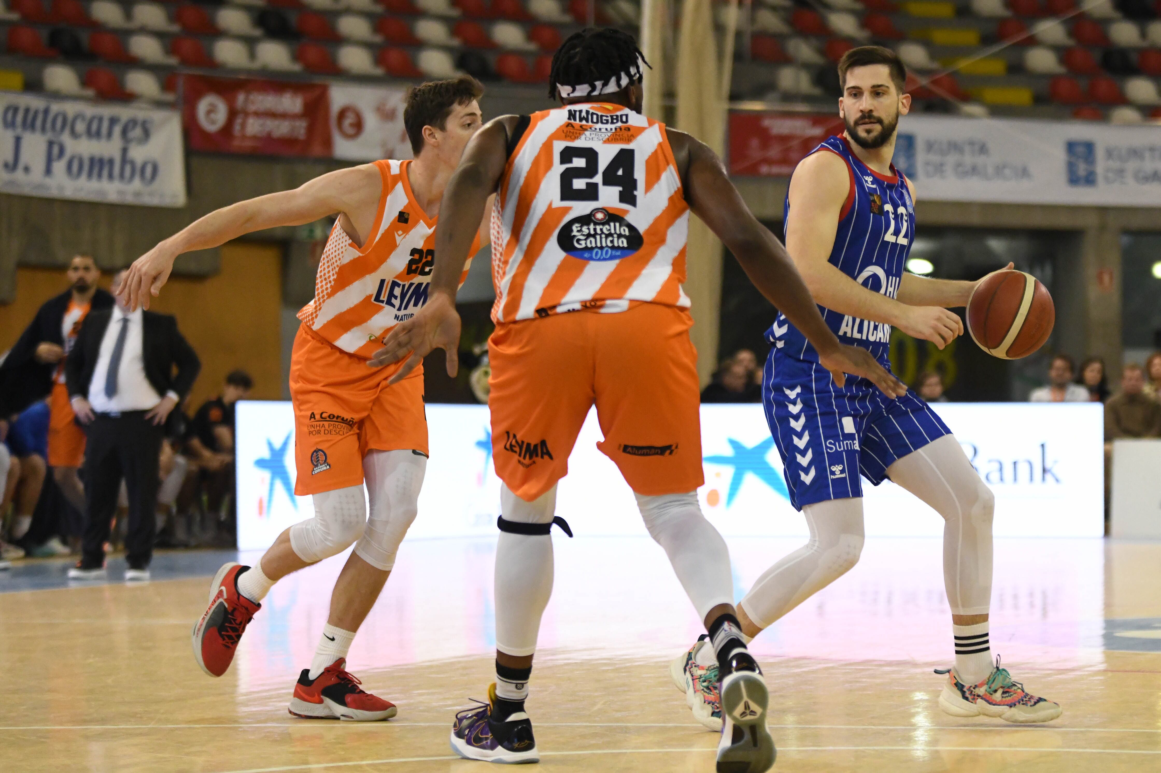 El jugador del HLA Alicante, Rakocevic, maneja el balón ante dos jugadores de Leyma Coruña