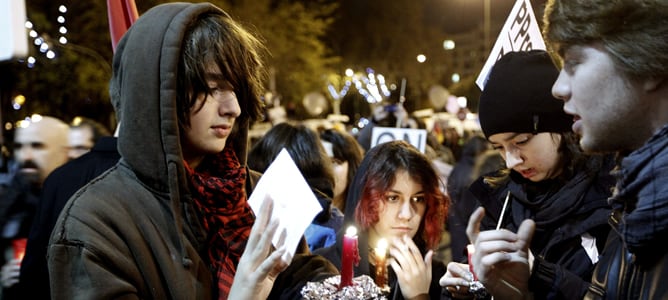 Varios jóvenes portan velas en la manifestación silenciosa convocada frente al Congreso por la coordinadora 25S contra los Presupuestos Generales del Estado.