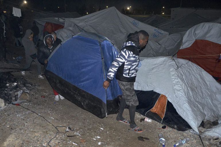 YAN10 LESBOS (GRECIA). Refugiados y migrantes trasladan sus tiendas de campaña durante un incendio en el campamento de refugiados en Lesbos (Grecia) hoy, 25 de noviembre de 2016. Una iraquí de 60 años y su nieto de 6 años murieron y otras dos personas res