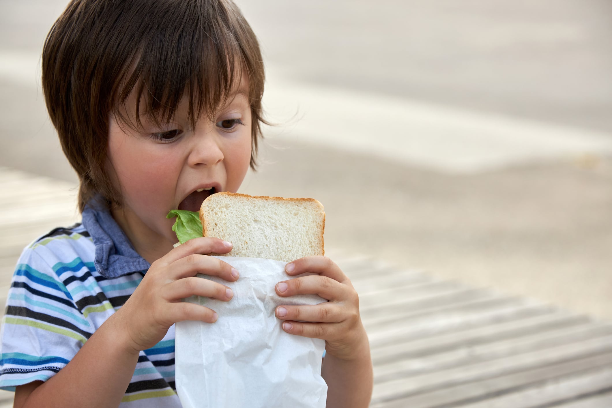Un niño, a punto de comerse el bocadillo.