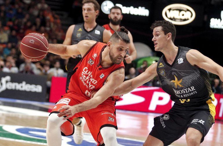 El escolta francés del Valencia Basket, Pierre Oriola (i), trata de evitar la defensa del base del Iberostar Tenerife, Rodrigo San Miguel (d), durante el partido correspondiente a la 13 jornada de la Liga ACB jugado esta noche en el pabellón de la Fuente 