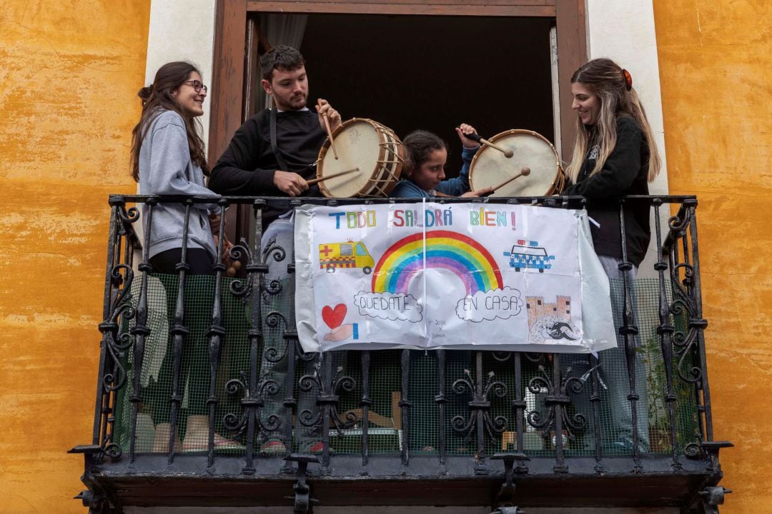 Varios miembros de una familia tocan el tambor desde el balcón de su vivienda de la ciudad murciana de Mula.