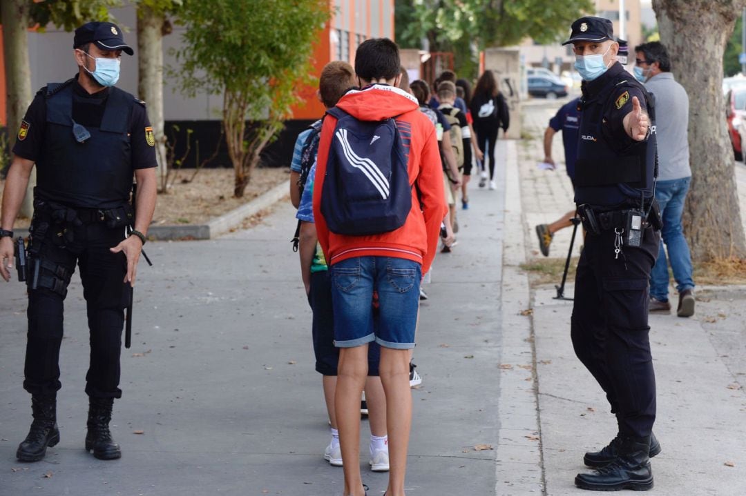 Efectivos de la Policia Nacional, controlan los accesos a un instituto en Valladolid, durante el primer día de la campaña de conciencia y vigilancia que junto a la Guardia Civil desplegarán en los colegios e institutos de Castilla y León para prevenir la expansión del coronavirus con motivo del inicio, a partir del 14 de septiembre, del curso escolar en las etapas de ESO y Bachillerato.