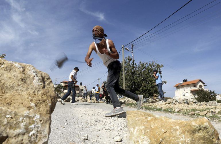 Un palestino lanza piedras durante los enfrentamientos registrados con soldados israelíes en el pueblo cisjordano de Seir, cerca de Hebrón