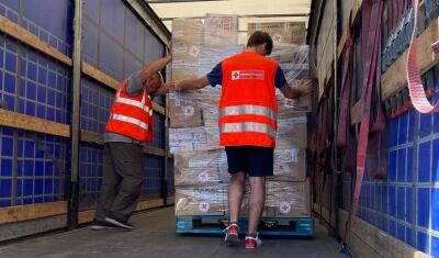 Voluntaris de la Creu Roja Andorrana carreguen el darrer comboi.