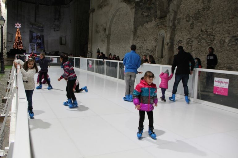 un grupo de niños disfrutan de la pista de hielo ecológico ubicada en el interior de la iglesia de San Francisco en Cuéllar