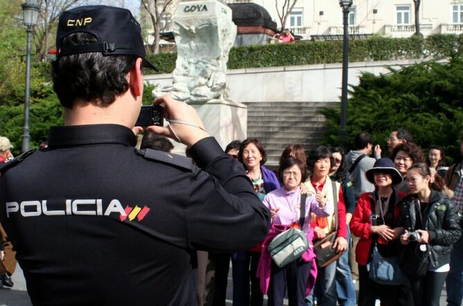 Un agente de la Policía Nacional toma una foto a un grupo de turistas