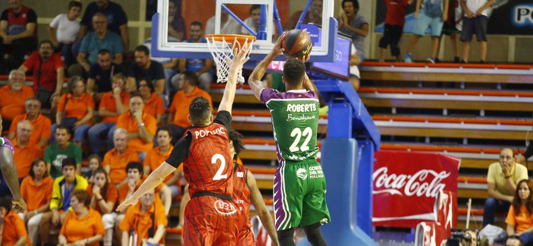 El croata Marko Popovic (2) intenta taponar el tiro del norteamericano Brian Roberts (22) durante el partido de la primera vuelta en el Fernando Martín que acabó con triunfo malagueño por 79 a 93 en el que fue debut en casa de la temporada.