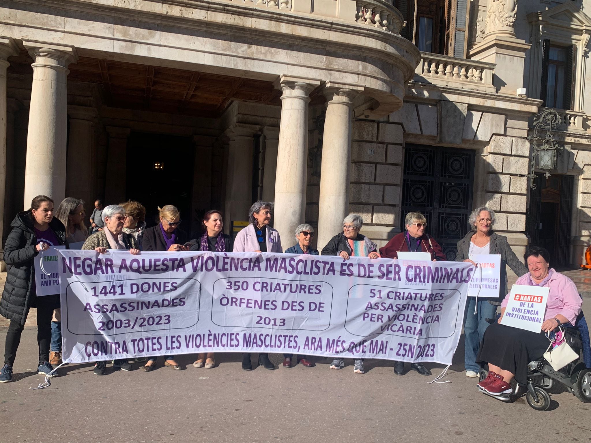 La Coordinadora Feminista de València posando con el cartel de su campaña para conmemorar el 25N, frente al Ayuntamiento de València