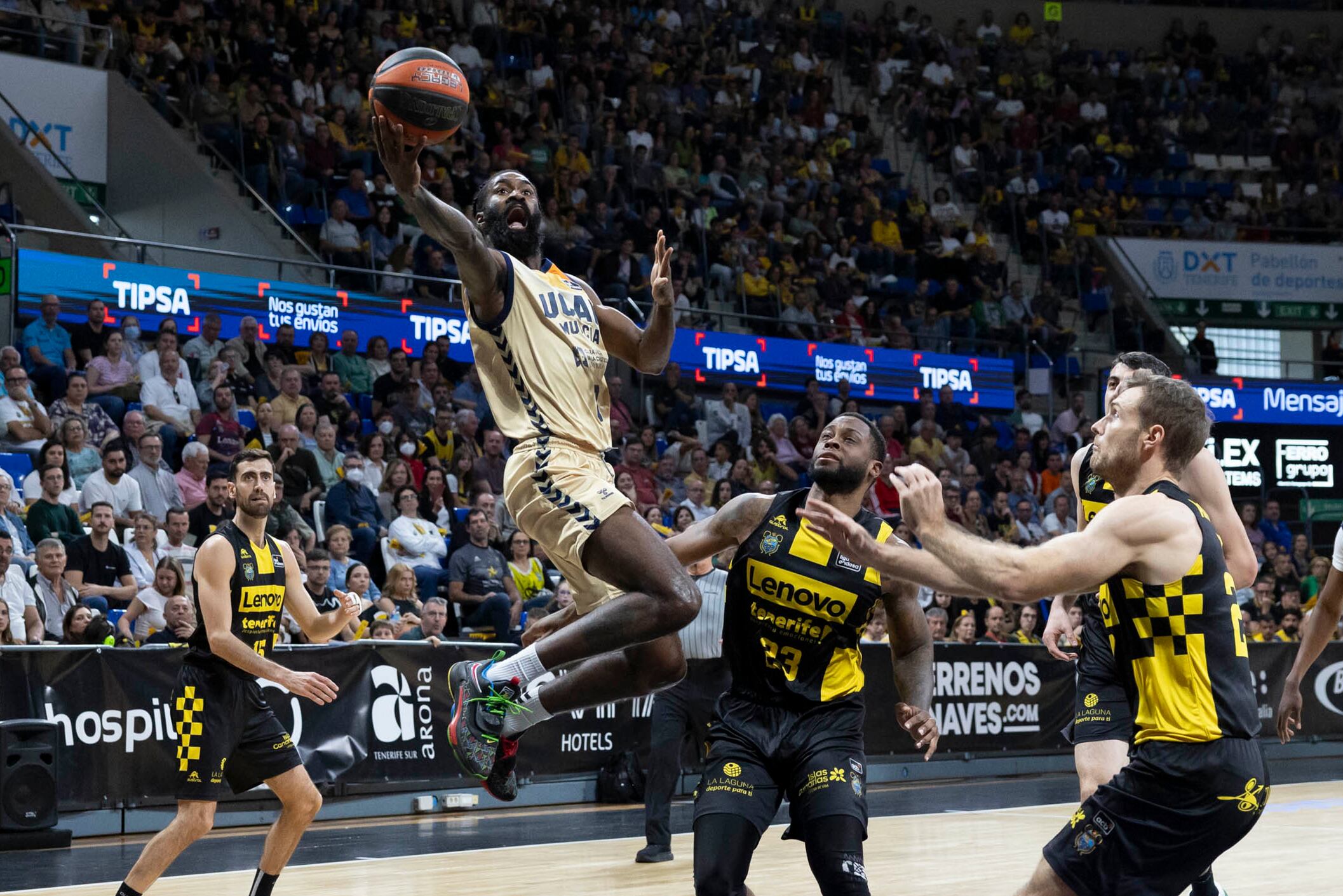 LA LAGUNA (TENERIFE), 27/01/2024.- El alero del UCAM Murcia, Sant-Roos (i), realiza un tiro a canasta ante la presencia de los jugadores del Lenovo Tenerife, durante el partido de la jornada 20 de la Liga ACB que enfrentó a ambos equipos este sábado en el pabellón Santiago Martín en La Laguna, Tenerife. EFE/ Miguel Barreto
