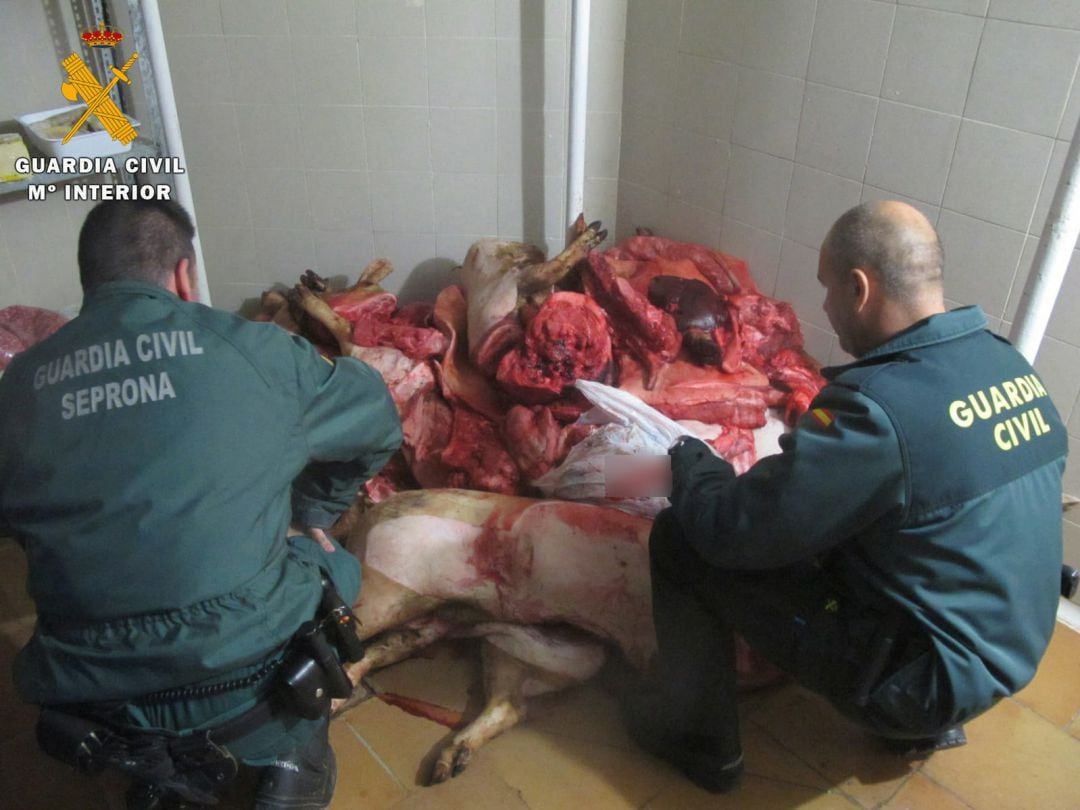 Unos agentes inspecionan la carne.