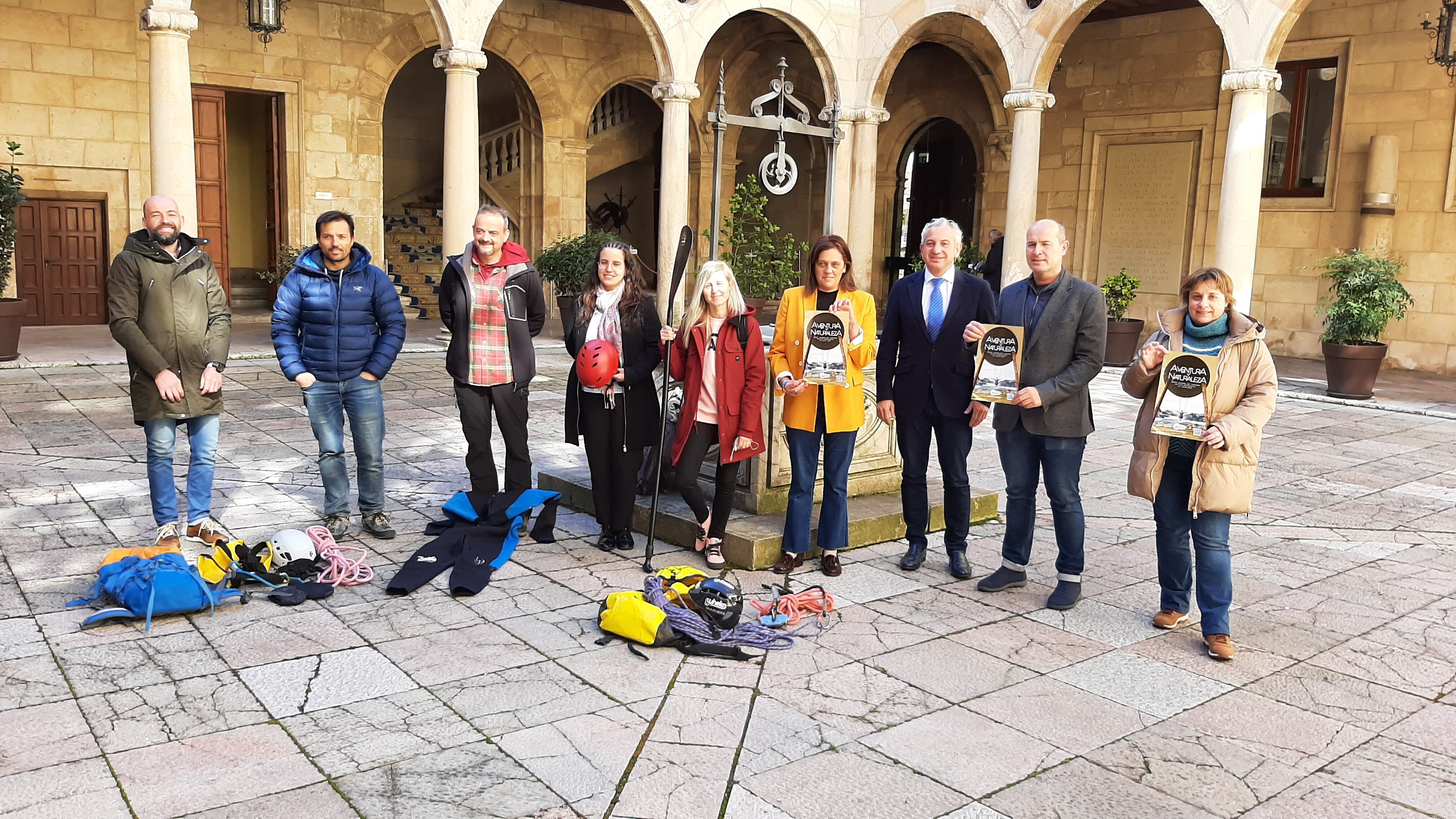 Representantes de la Diputación de León y de las empresas leonesas involucradas posan junto al cartel de actividades de aventura