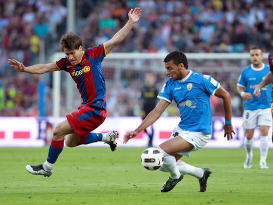 El defensa brasileño del UD Almería Míchel Macedo pugna por un balón con el delantero del F.C. Barcelona Bojan Krkic, que se ha tenido que retirar en el partido entre ambos equipos en el Camp Nou