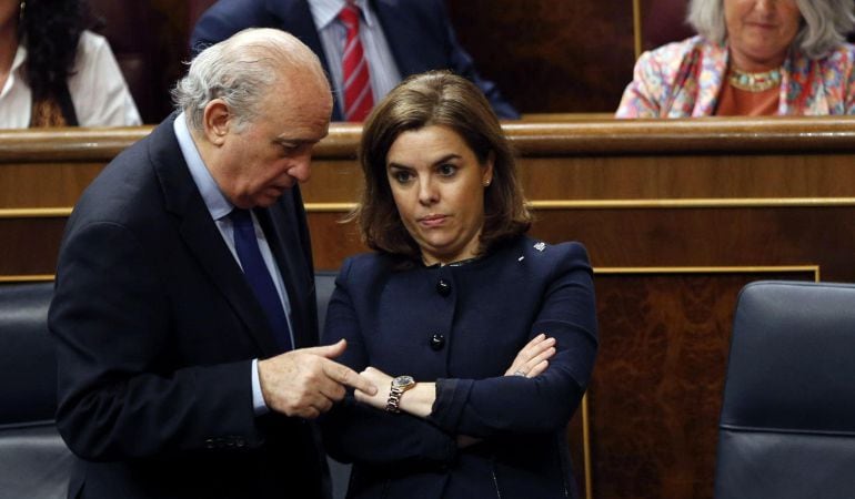 La vicepresidenta del Gobierno, Soraya Sáenz de Santamaría, junto al ministro del Interior, Jorge Fernández Díaz, tras la votación sobre la reforma de la ley del aborto.