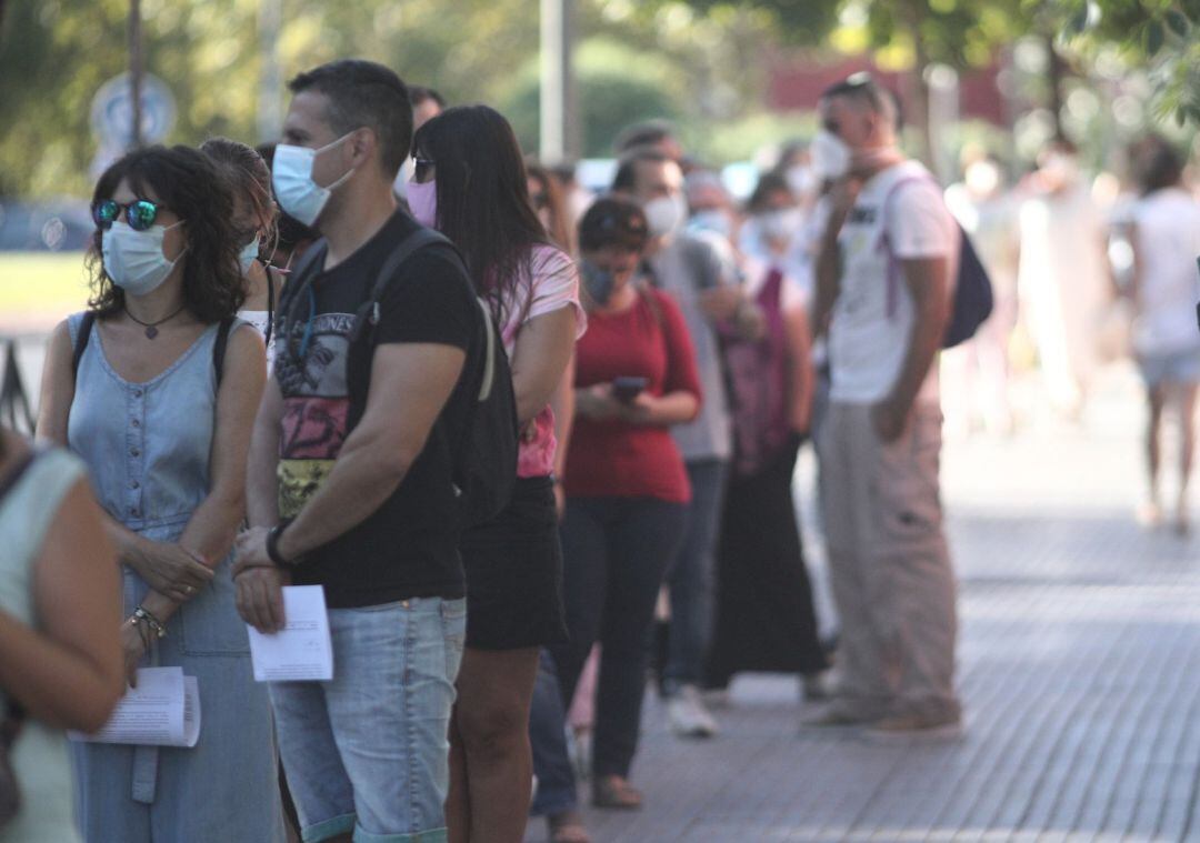 Un grupo de personas hacen cola en un cribado masivo