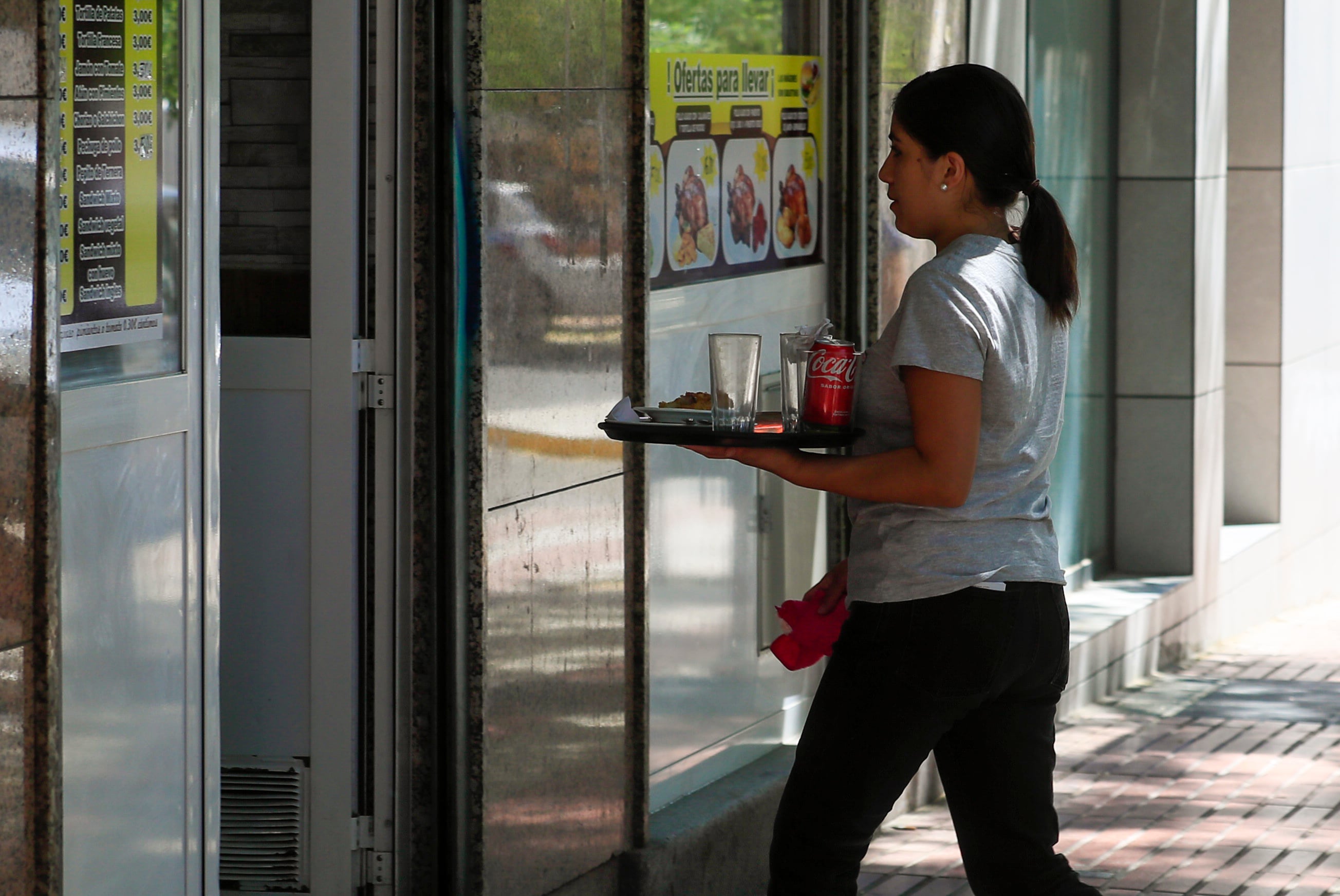 MADRID, 02/08/2023.- Una camarera retira un servicio en una cafetería de Madrid este miércoles. La Seguridad Social sumó 21.945 ocupados de media en julio, hasta un nuevo récord de 20.891.885 afiliados, mientras que el paro se redujo en 10.968 personas hasta 2.677.874, mínimo desde 2008. EFE/ Fernando Alvarado
