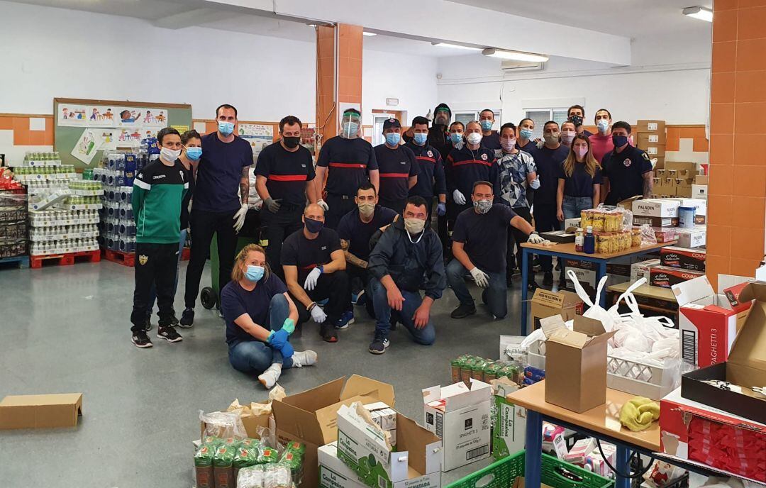 Voluntarios y voluntarias de la Asociación de Vecinos de El Arenal, entre ellos Bomberos, agentes de Policía Local y Protección Civil que han prestado su apoyo a las familias del barrio en Córdoba 