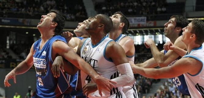 Los jugadores del Real Madrid, Marcus Slaughter (c) Felipe Reyes (c, detrás) y Jaycee Carroll (d) luchan por el rebote con los jugadores del Blusens Monbus Oriol Junyent (i), Levon Kendall (2i) y Alberto Corbacho (2d), en el primer partido de la eliminato