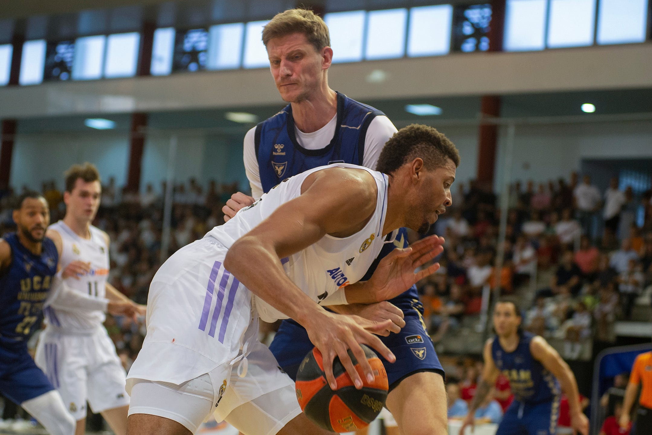 Puertollano (Ciudad Real), 17/09/2022.- El pivot caboverdiano del Real Madrid, Walter Tavares (c), con el balón ante la defensa del jugador de UCAM Murcia durante el partido correspondiente al V Trofeo Luis Casimiro que han disputado hoy sábado en el pabellón Antonio Rivilla de Puertollano. EFE/Jesús Monroy.
