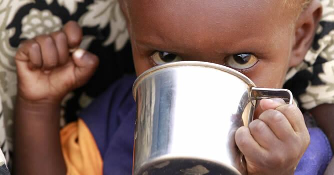 Un niño recién llegado al campamento de Dadaab recibe alimento