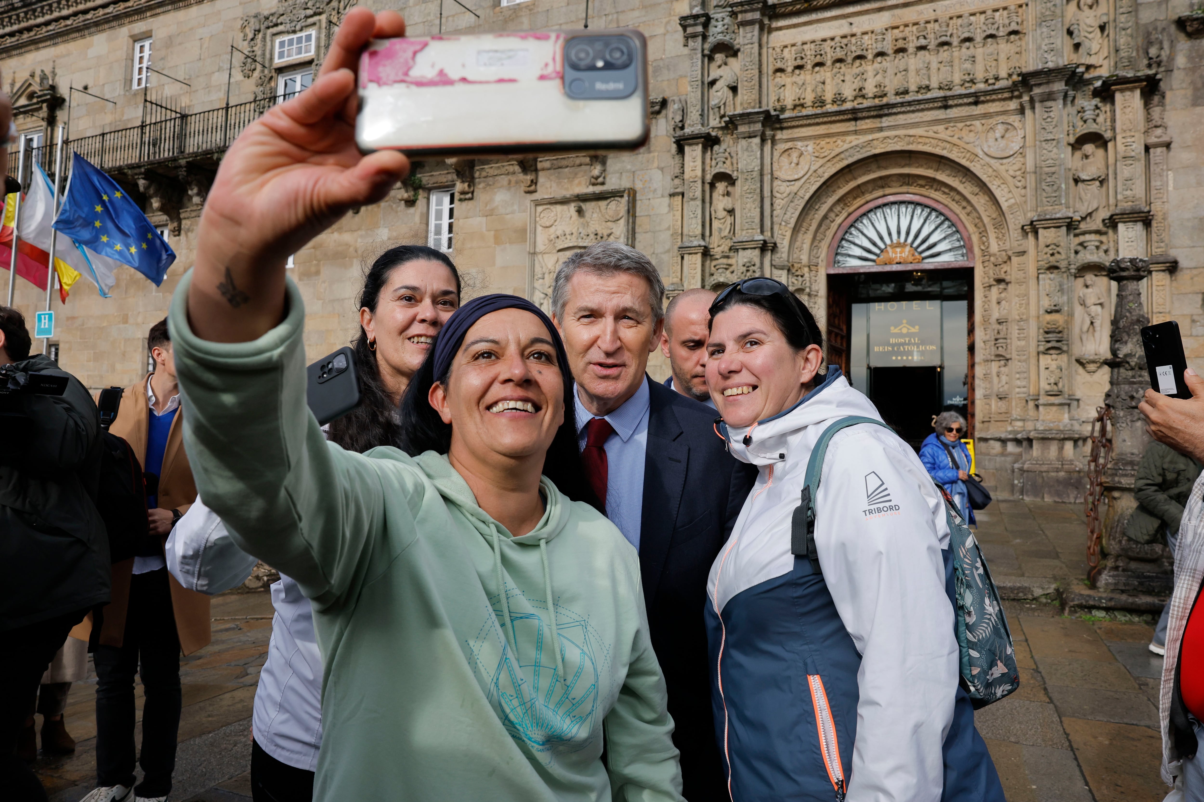 SANTIAGO DE COMPOSTELA, 15/11/2024.- El presidente del Partido Popular, Alberto Núñez Feijóo (c), se fotografía a la salida de un desayuno organizado por la Confederación de Empresarios de Galicia, este viernes, en Santiago de Compostela. EFE/ Lavandeira
