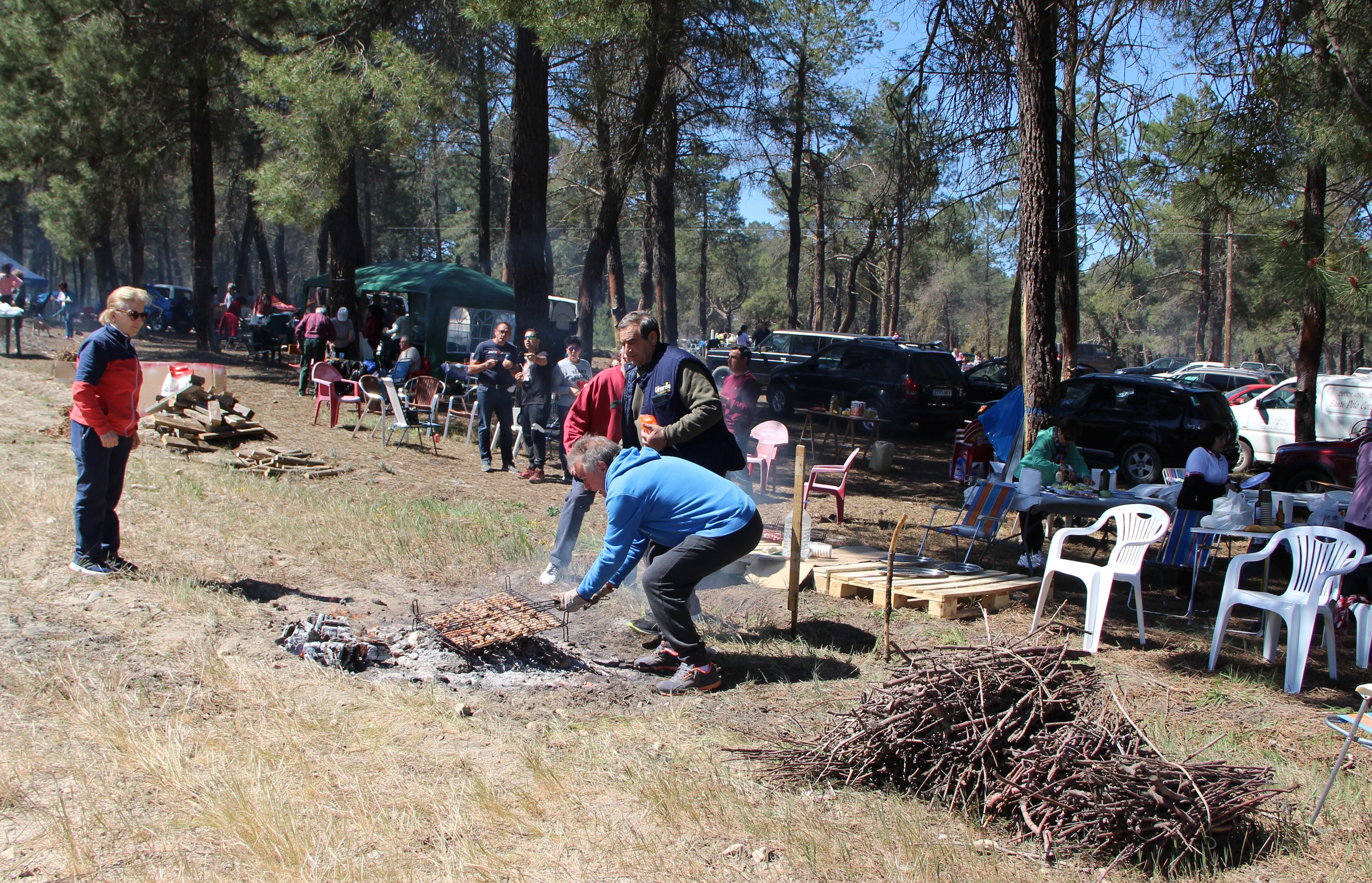 Un grupo de amigos prepara las chuletas en las parrillas