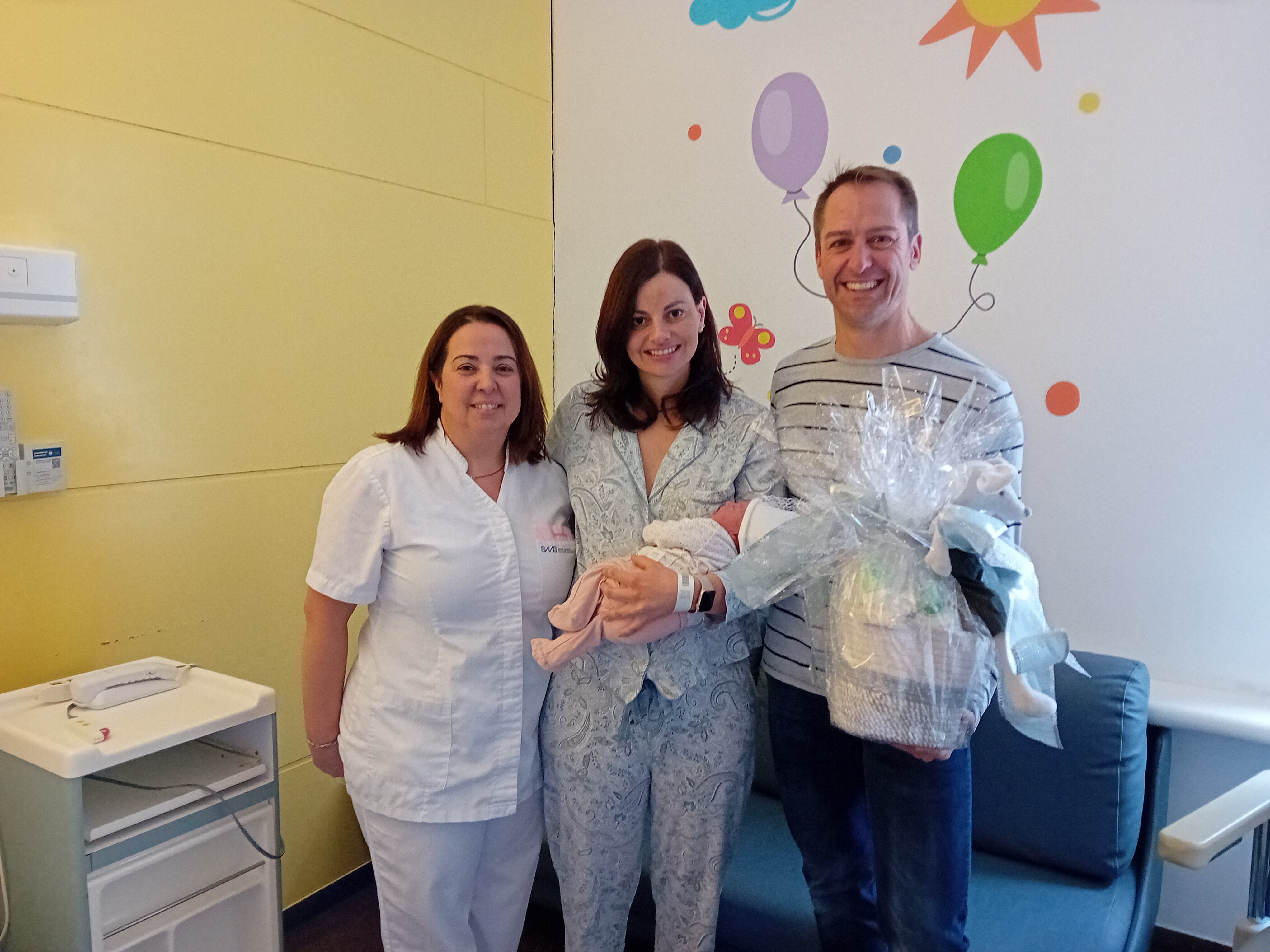 La família del primer nadó del 2024, amb la petita en braços i una infermera del SAAS aquest dimecres a l'hospital de Meritxell.