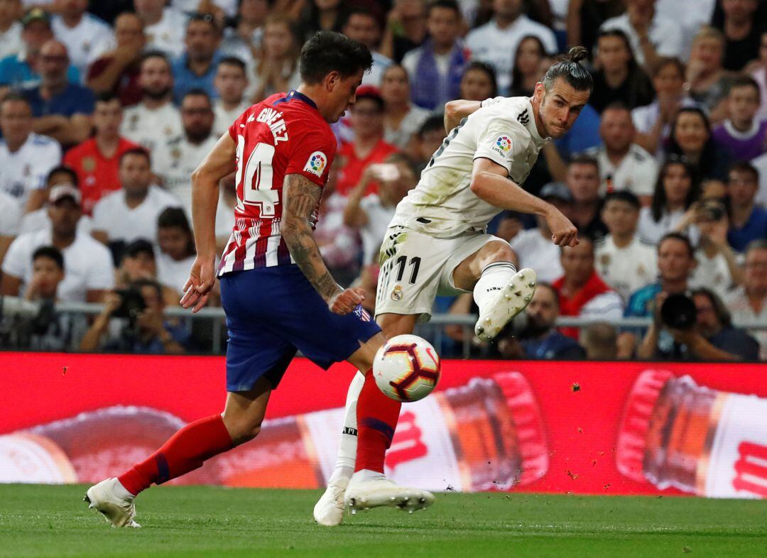 Gareth Bale intenta un centro en el derbi entre el Real Madrid y el Atlético.