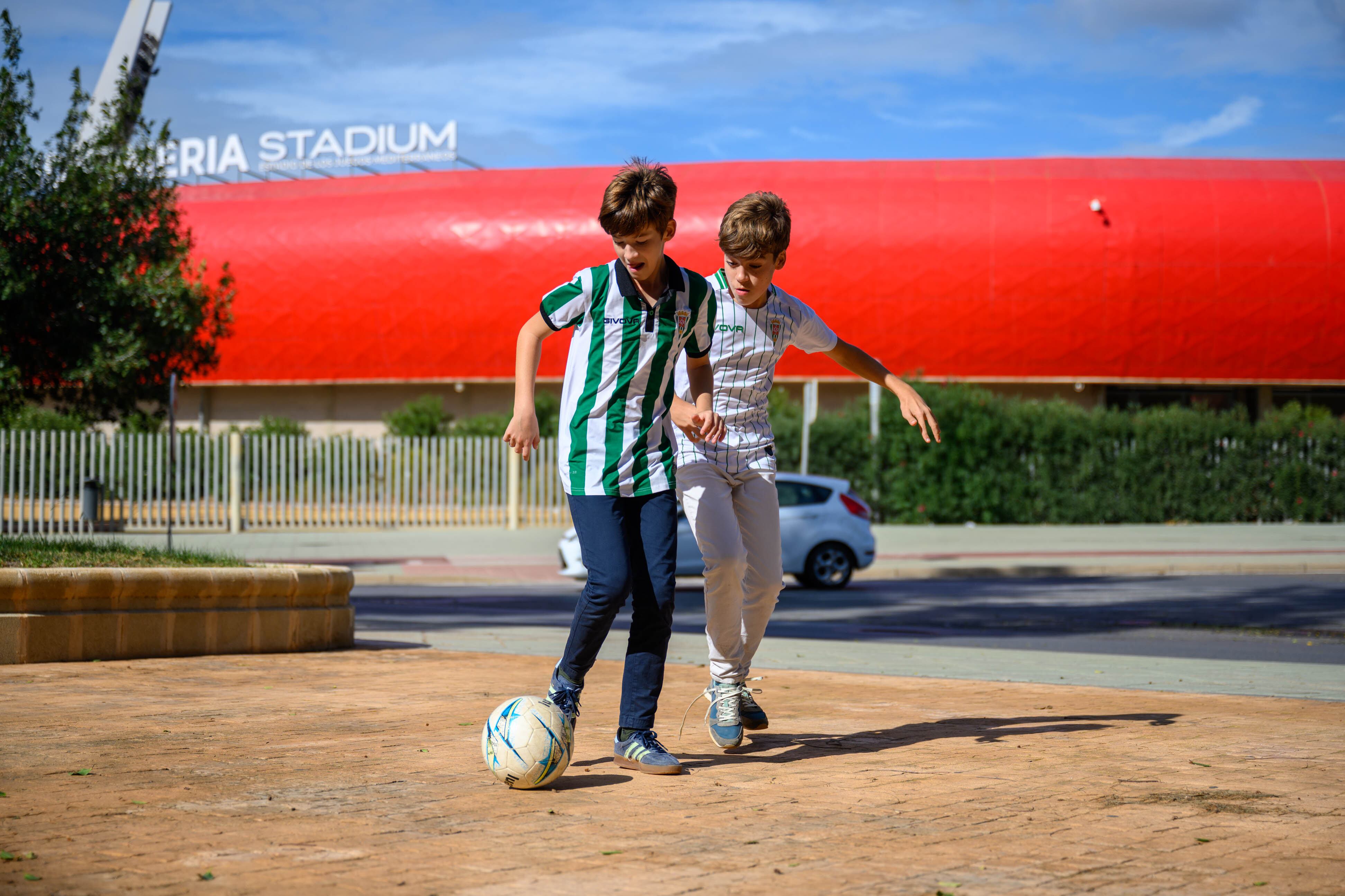 Dos aficionados del Córdoba que viajaron a Almería jugando en los exteriores del Mediterráneo este domingo.