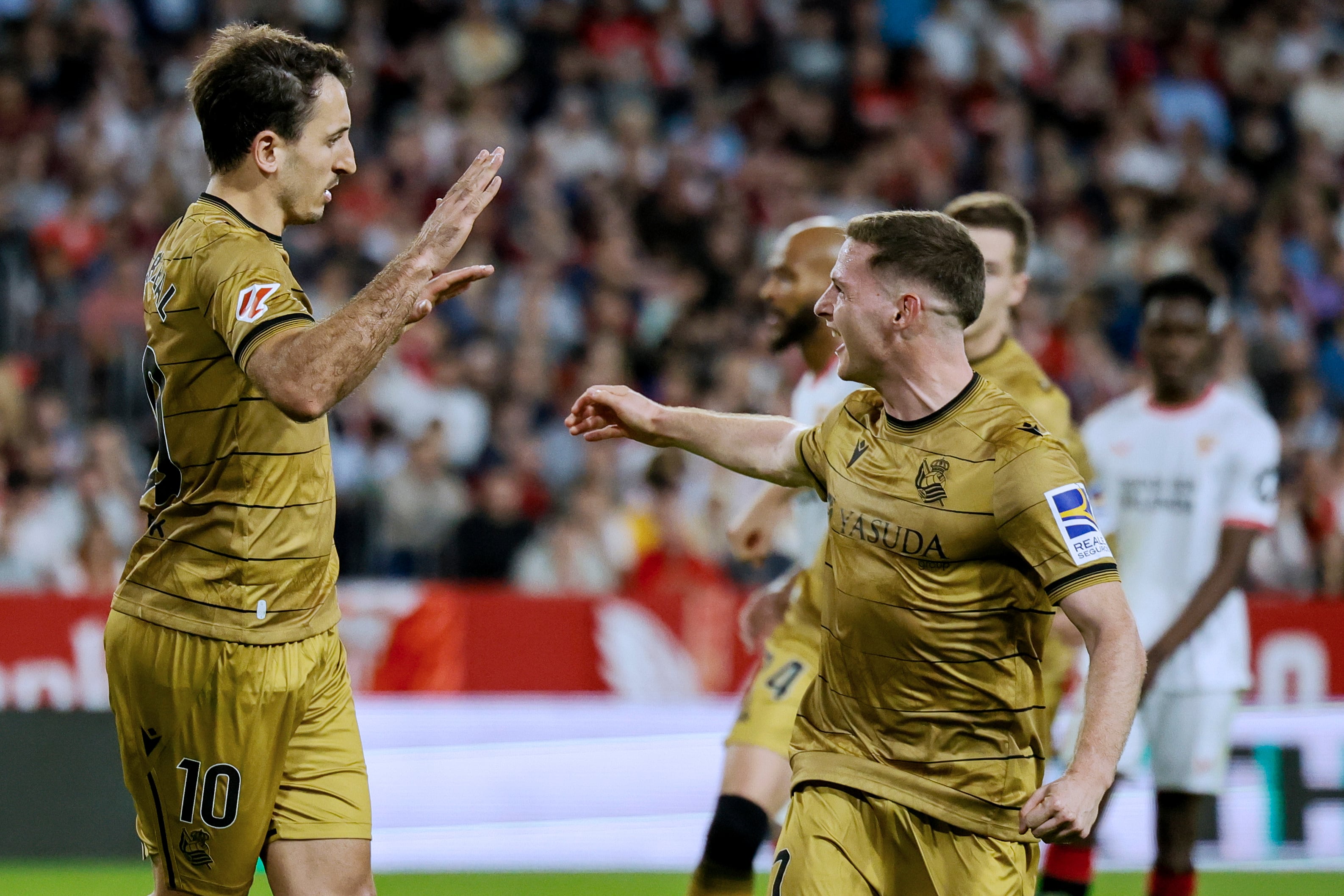 SEVILLA, 03/11/2024.- El capitán de la Real Sociedad, Mikel Oyarzabal (izda), celebra con su compañero Zubimendi el segundo gol conseguido ante el Sevilla FC, durante el partido de LaLiga que les enfrenta en el estadio Sánchez Pizjuán de Sevilla este domingo. EFE/José Manuel Vidal
