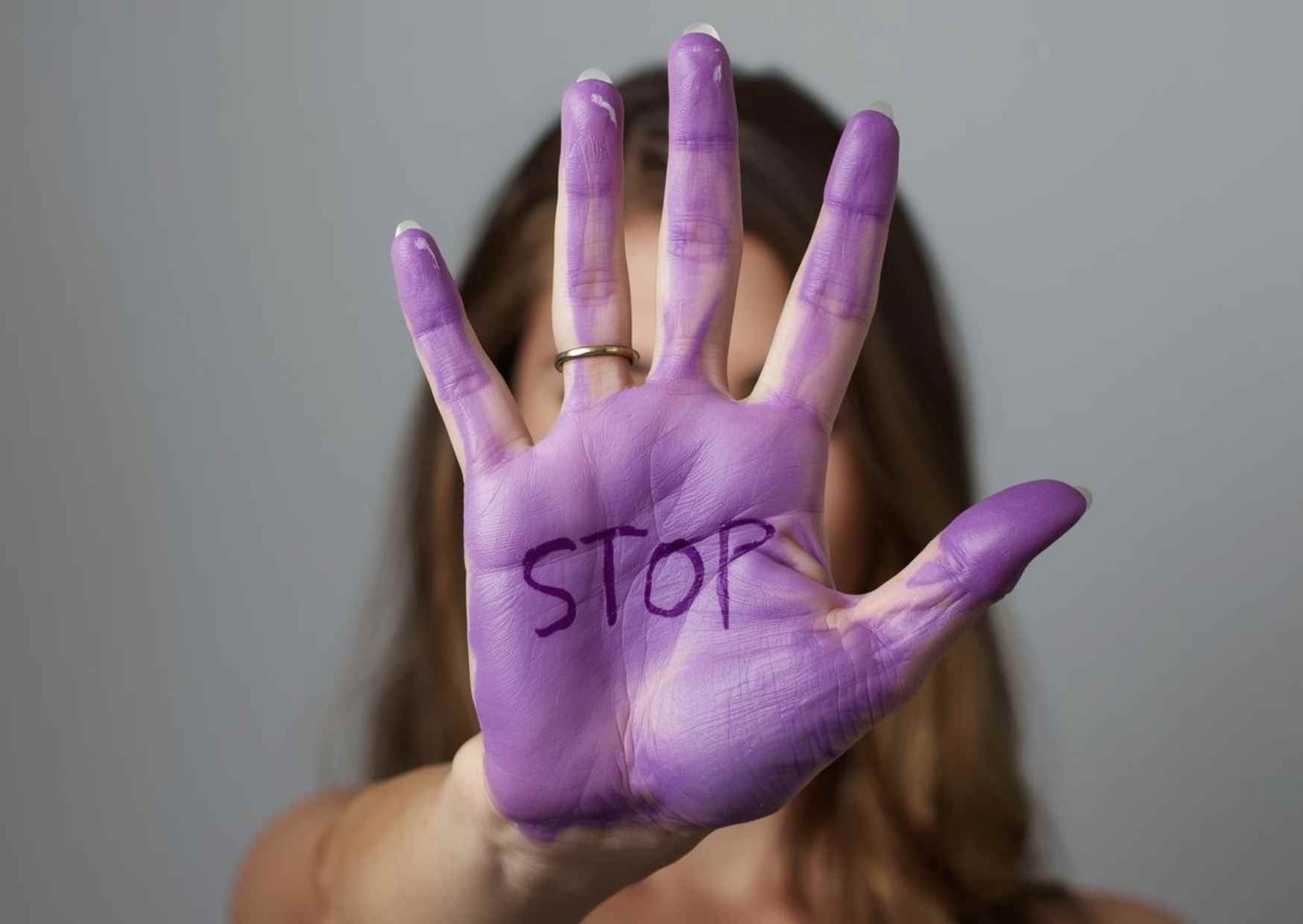 Mujer con la mano teñida de morado como símbolo contra la violencia de género