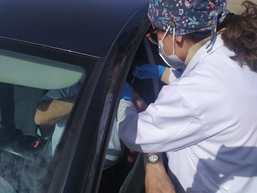 Una enfermera vacuna a un paciente desde su coche en las inmediaciones del centro de salud Practicante Cándido Pozuelo