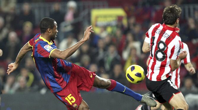 El centrocampista maliense del F. C. Barcelona, Seydou Keita (i), dispara ante Carlos Gurpegui , centrocampista del Ath. de Bilbao, durante el encuentro, correspondiente a la ida de los octavos de final de la Copa del Rey, que ambos equipos disputan esta noche en el estadio del Nou Camp, en Barcelona